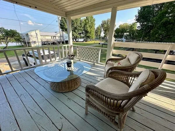 a balcony with wooden floor table and chairs