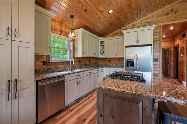 a kitchen with stainless steel appliances granite countertop a sink a stove and a refrigerator