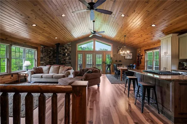 a living room with furniture a large window and wooden floor
