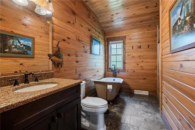 a bathroom with a granite countertop toilet sink and mirror