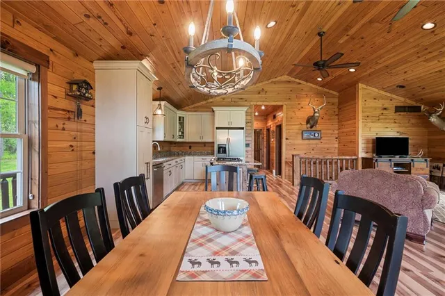 a view of a dining room with furniture a chandelier and wooden floor