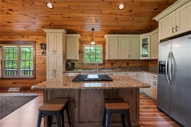 a kitchen with granite countertop a table chairs stove a sink dishwasher and cabinets with wooden floor
