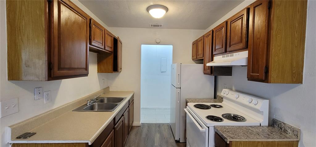 3120 Southwest 26th Terrace Gainesville, FL 32608 - Photo 19 of 25 a kitchen with stainless steel appliances granite countertop a sink stove and refrigerator