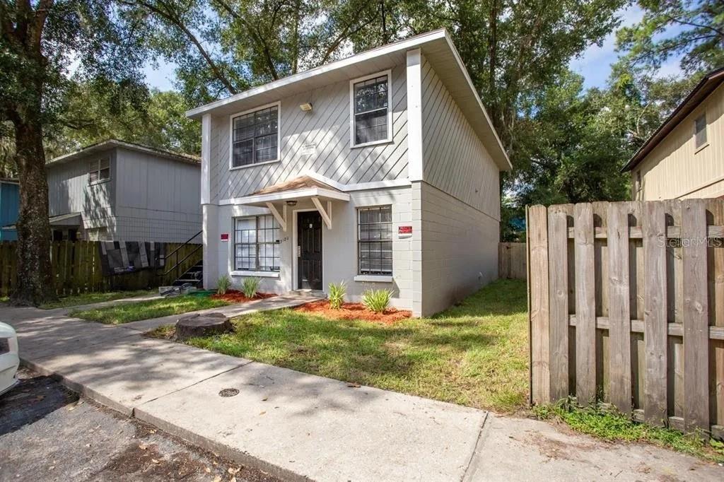 3120 Southwest 26th Terrace Gainesville, FL 32608 - Photo 2 of 25 a front view of a house with a yard garage and outdoor seating