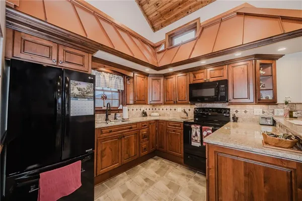 a kitchen with stainless steel appliances granite countertop a sink a stove and a refrigerator