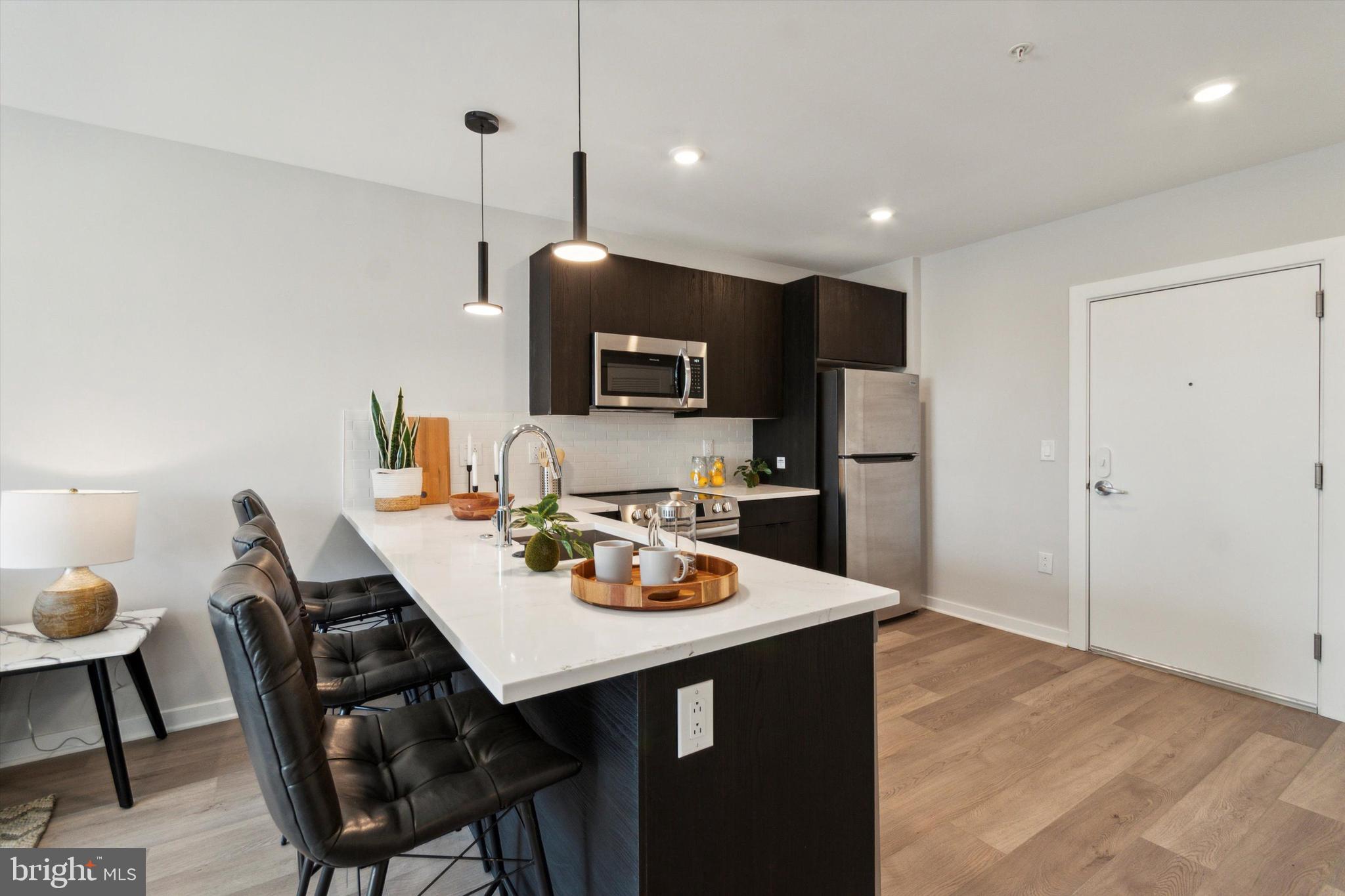 3449 Scotts Lane, Unit B419 Philadelphia, PA 19129 - Photo 8 of 14 a open kitchen with a dining table and chairs