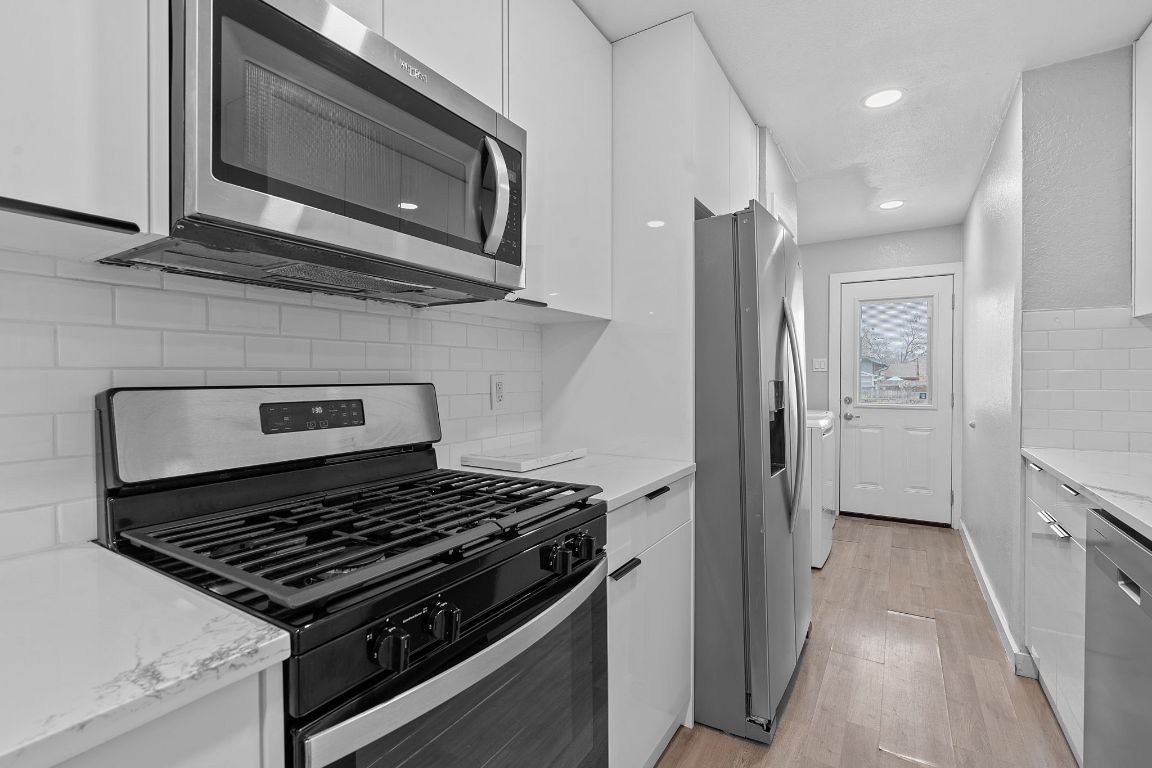 16131 Stoneham Circle Pflugerville, TX 78660 - Photo 8 of 19 a kitchen with stainless steel appliances granite countertop a stove and a microwave