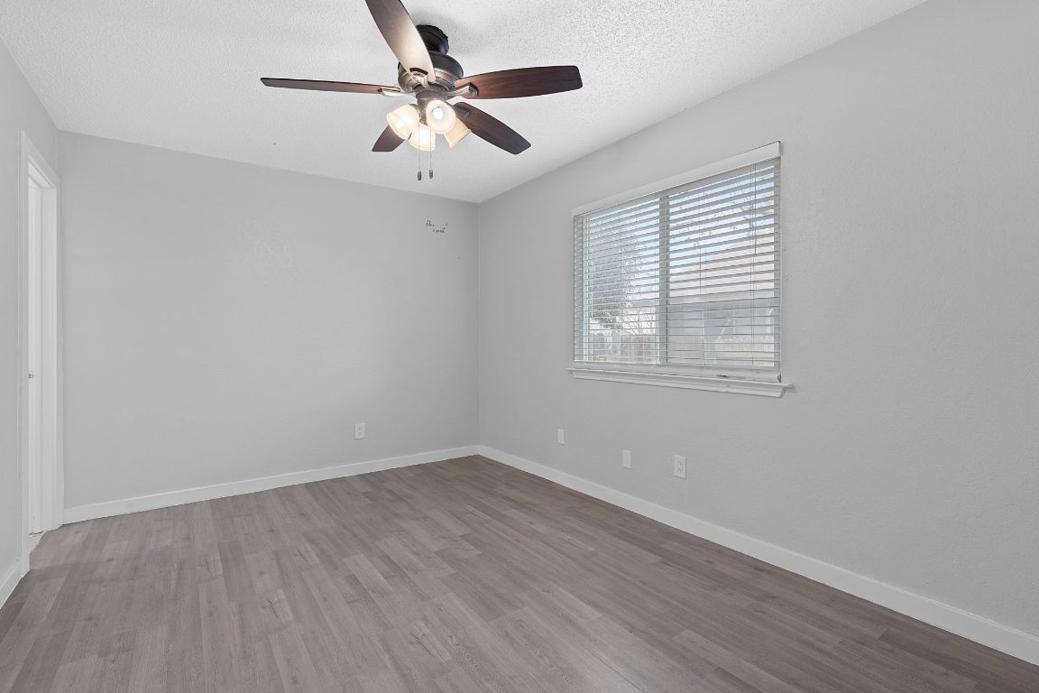 16131 Stoneham Circle Pflugerville, TX 78660 - Photo 9 of 19 wooden floor in an empty room with a window