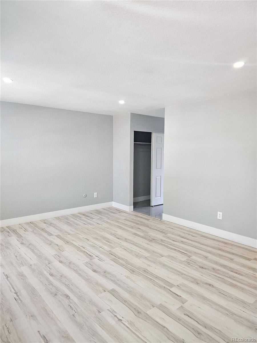 4716 Freeport Way Denver, CO 80239 - Photo 10 of 29 a view of an empty room with wooden floor and a window