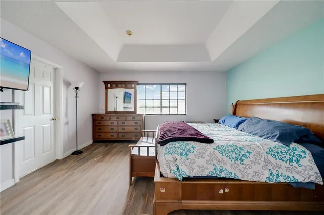 a bedroom with a bed and wooden floor