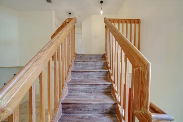 a view of staircase with wooden floor and white walls