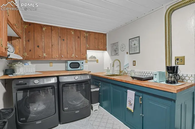 a utility room with stainless steel appliances granite countertop a sink and a stove