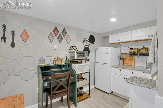 a kitchen with a refrigerator and a stove top oven