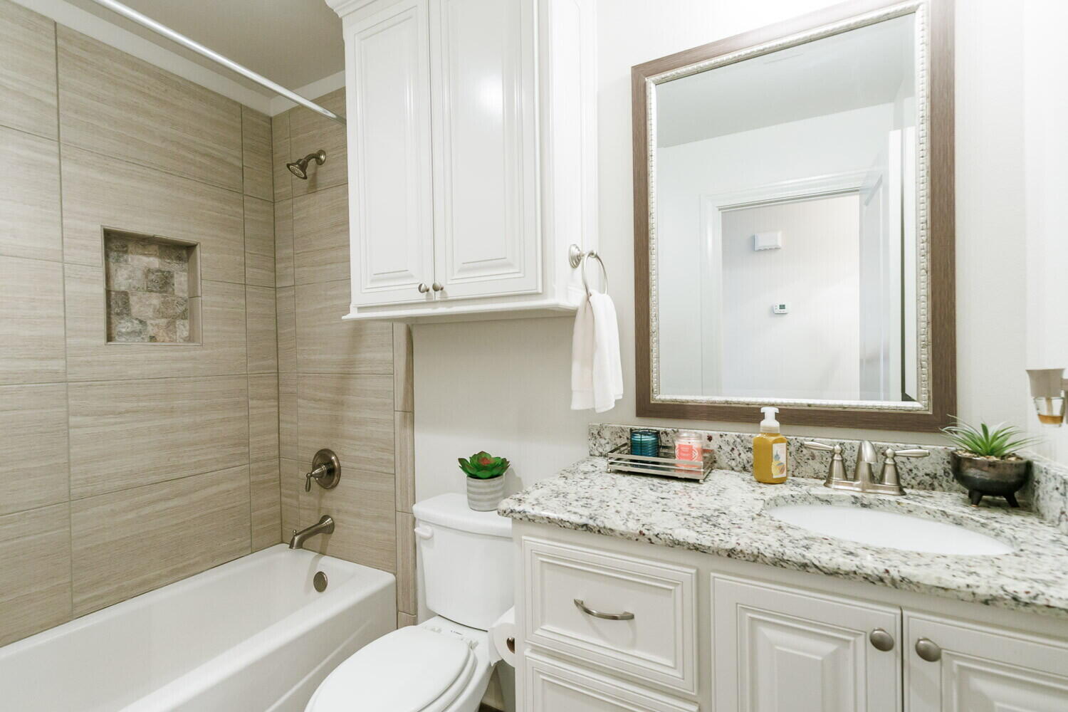 3812 135th Street Lubbock, TX 79423 - Photo 24 of 41 a bathroom with a granite countertop sink a toilet and bathtub