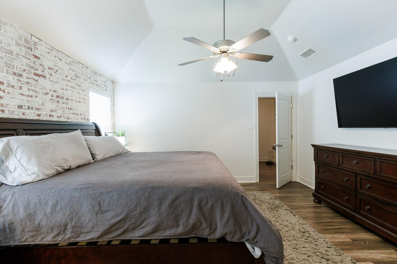 3812 135th Street Lubbock, TX 79423 - Photo 29 of 41 a bedroom with a bed and a flat tv screen on dresser