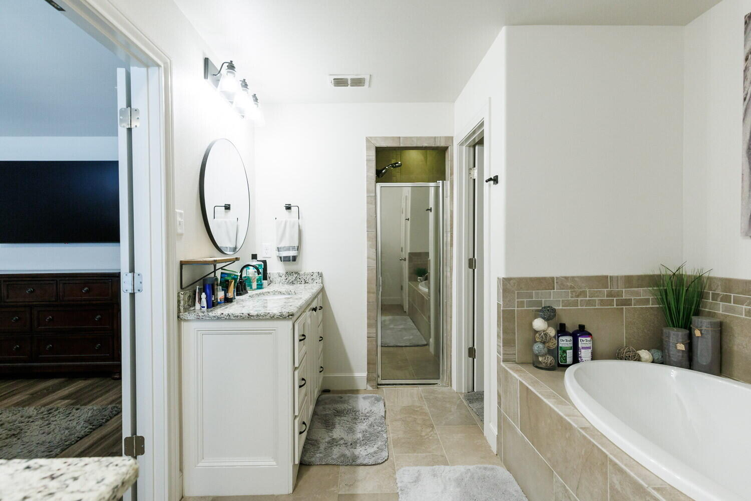 3812 135th Street Lubbock, TX 79423 - Photo 33 of 41 a bathroom with a bathtub a sink a mirror and a shower