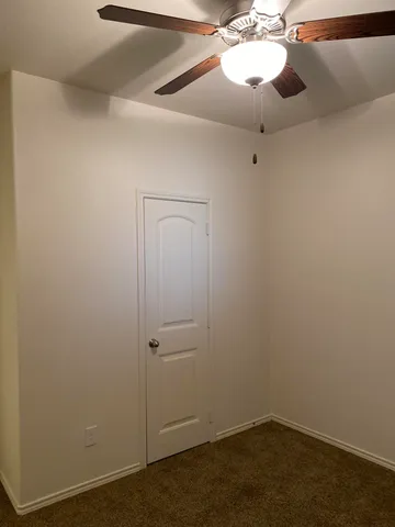 an empty room with a fan and a fan