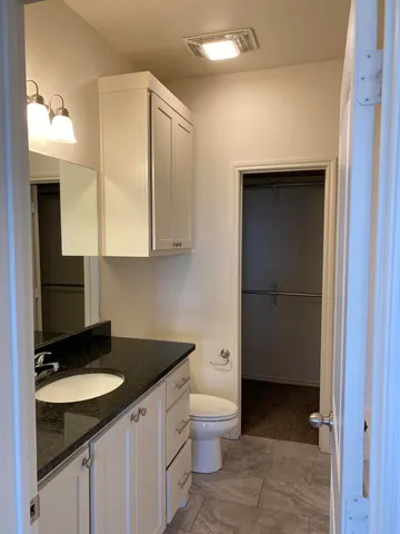 a bathroom with a granite countertop sink and a mirror