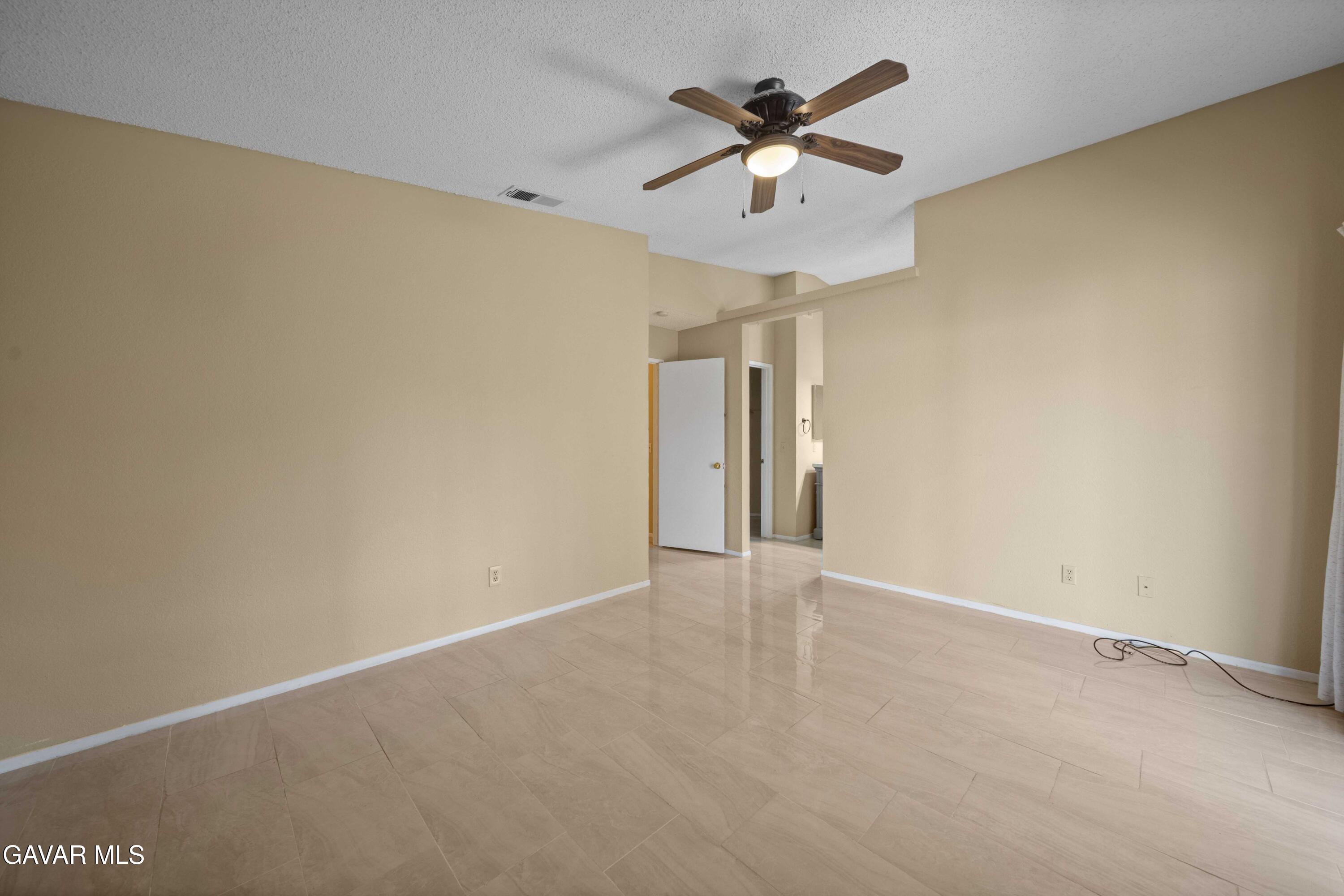 43815 Silver Bow Road Lancaster, CA 93535 - Photo 15 of 20 an empty room with a chandelier fan and a ceiling fan