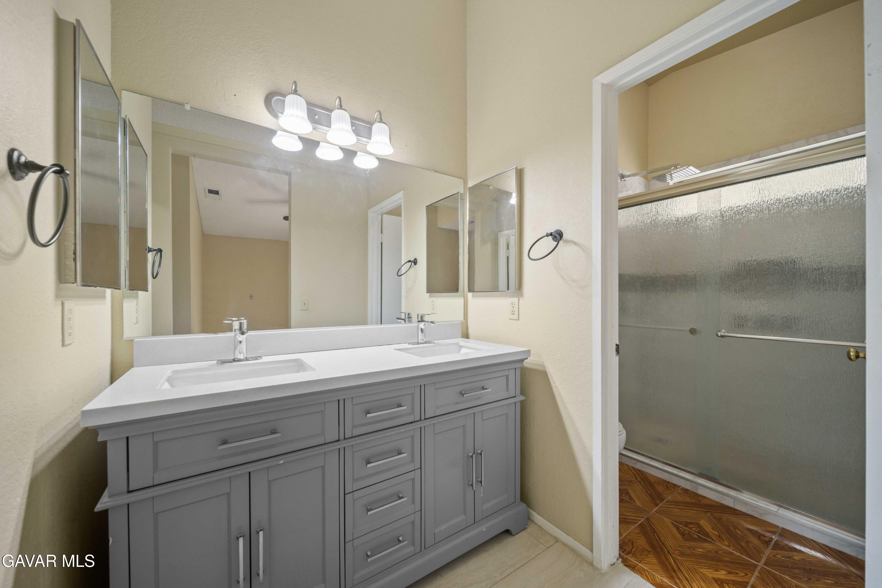 43815 Silver Bow Road Lancaster, CA 93535 - Photo 17 of 20 a bathroom with a double vanity sink mirror and shower