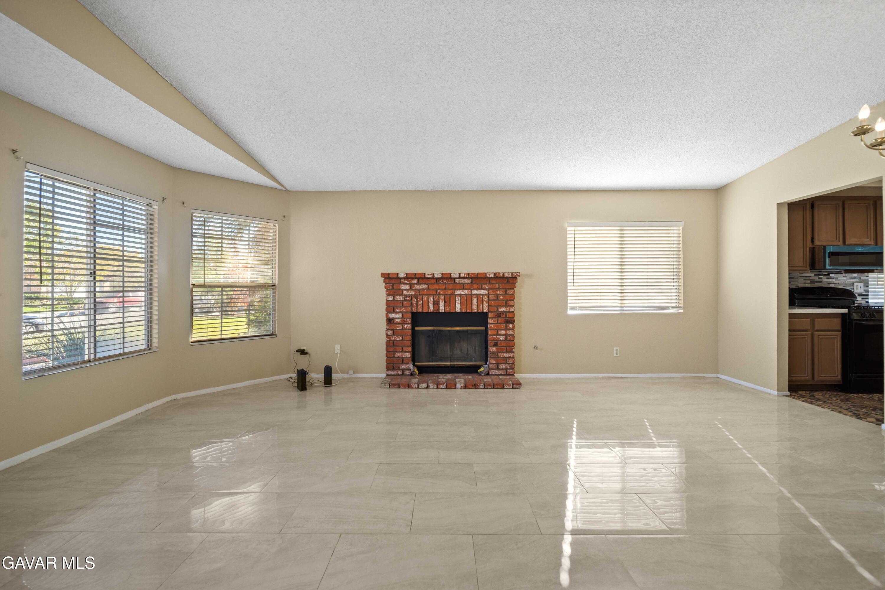 43815 Silver Bow Road Lancaster, CA 93535 - Photo 3 of 20 a view of an empty room with a fireplace and a window