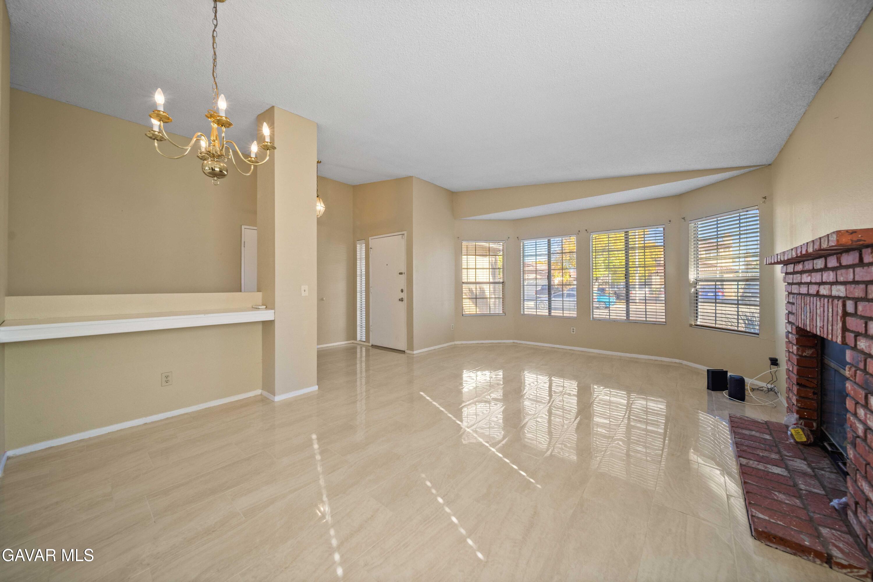 43815 Silver Bow Road Lancaster, CA 93535 - Photo 5 of 20 a view of an empty room with a fireplace and a window