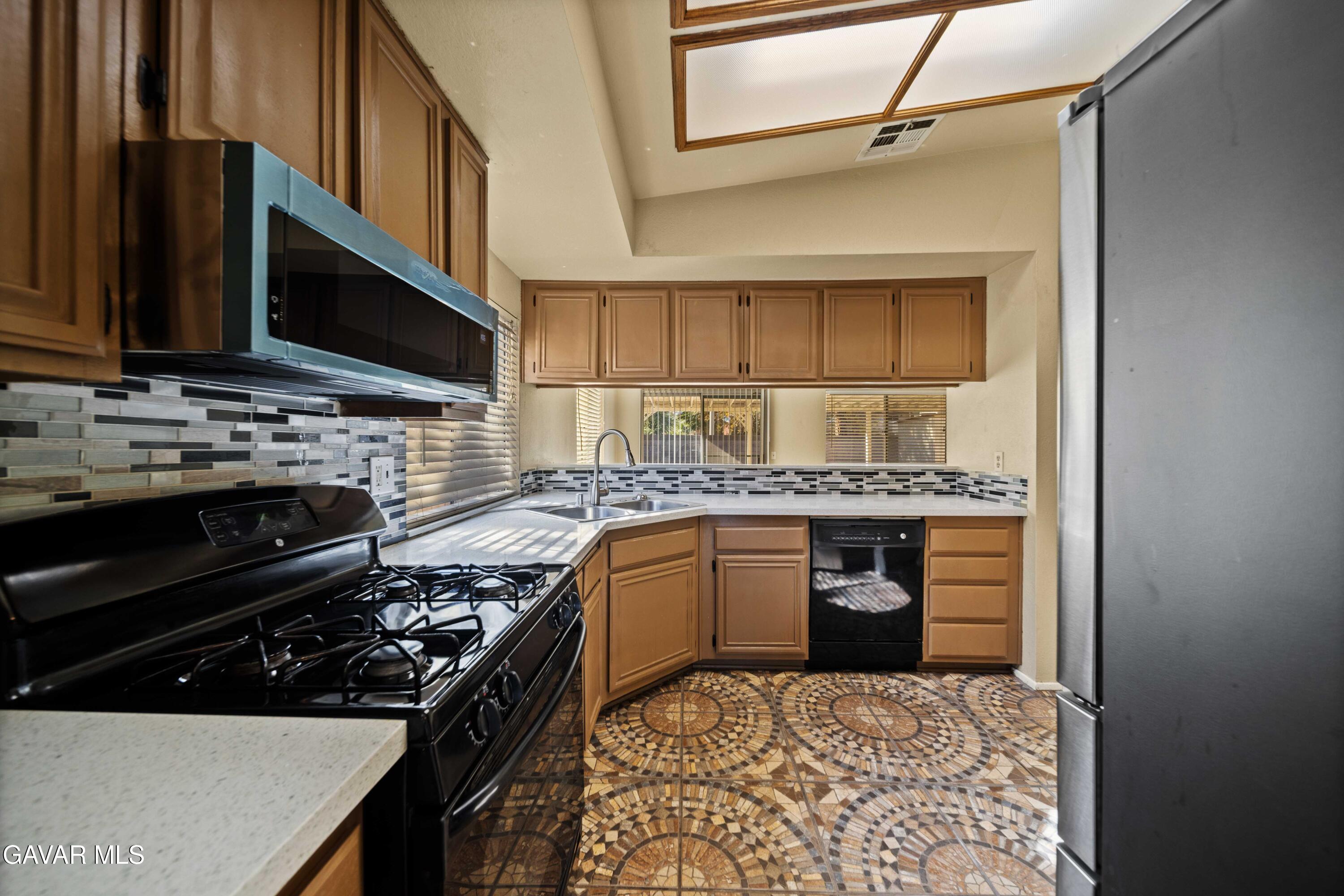 43815 Silver Bow Road Lancaster, CA 93535 - Photo 6 of 20 a kitchen with a stove and a sink