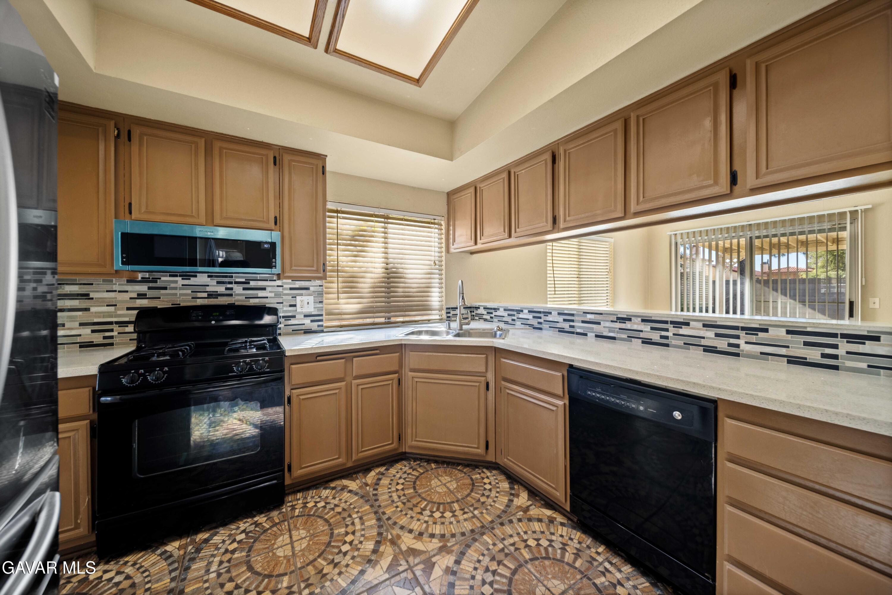 43815 Silver Bow Road Lancaster, CA 93535 - Photo 8 of 20 a kitchen with a sink stove and microwave