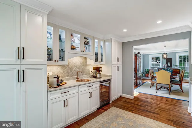 a kitchen with stainless steel appliances white cabinets and wooden floor
