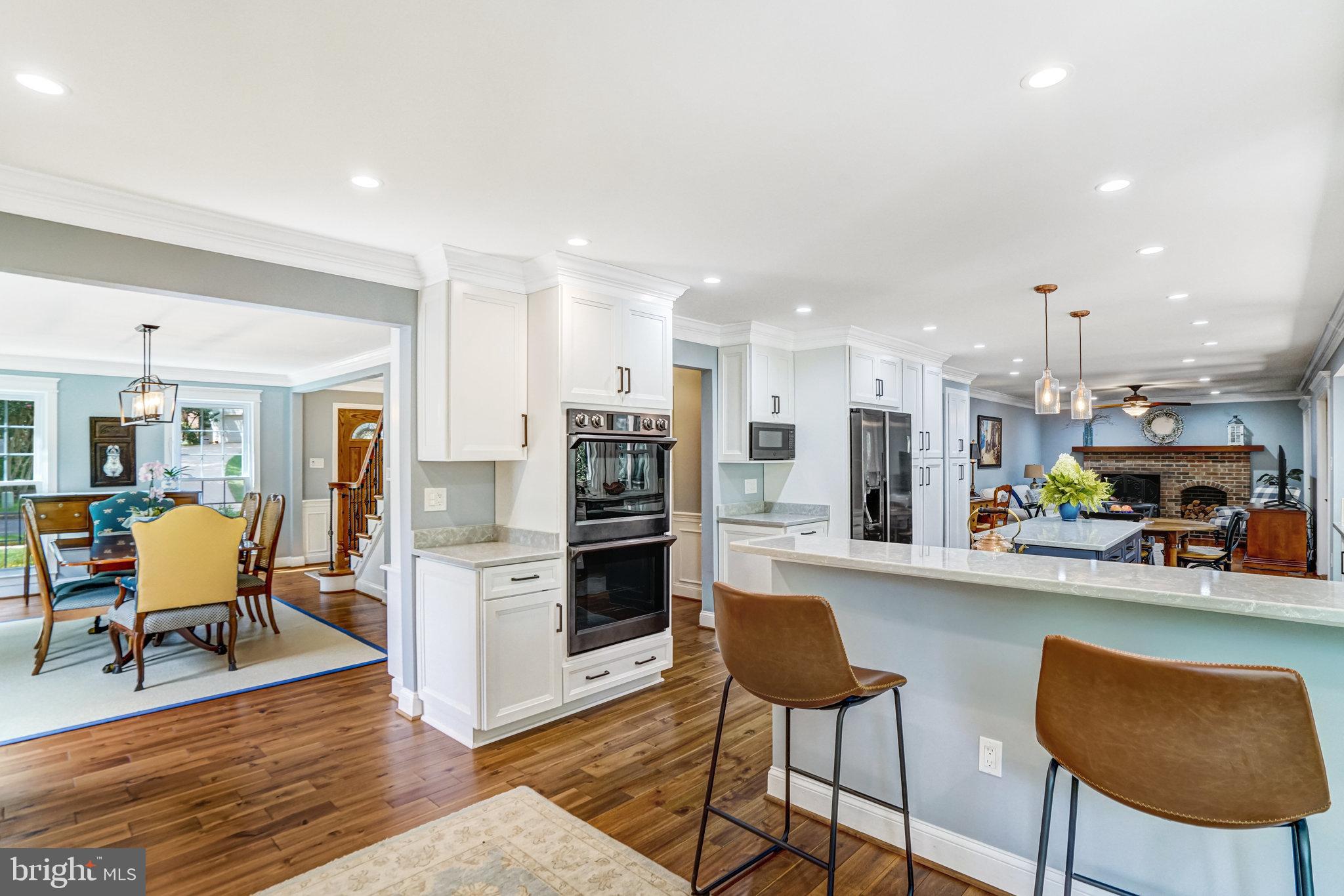 6815 Bluecurl Circle Springfield, VA 22152 - Photo 13 of 49 a kitchen with stainless steel appliances kitchen island granite countertop dining table chairs and a refrigerator