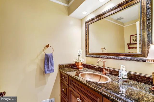 a bathroom with a granite countertop double vanity sink and a mirror