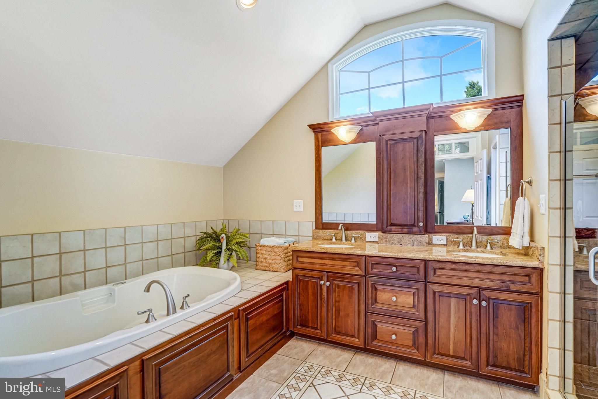 6815 Bluecurl Circle Springfield, VA 22152 - Photo 26 of 49 a bathroom with a tub a double vanity sink and mirror