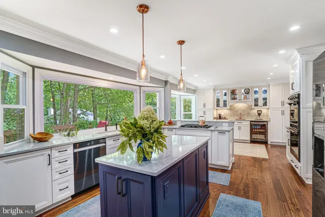 a kitchen with stainless steel appliances granite countertop sink stove and wooden floor
