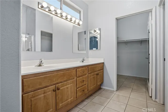 a spacious bathroom with a double vanity sink a mirror and a bathtub