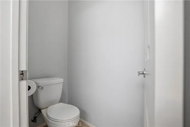 a white toilet sitting next to a white wall