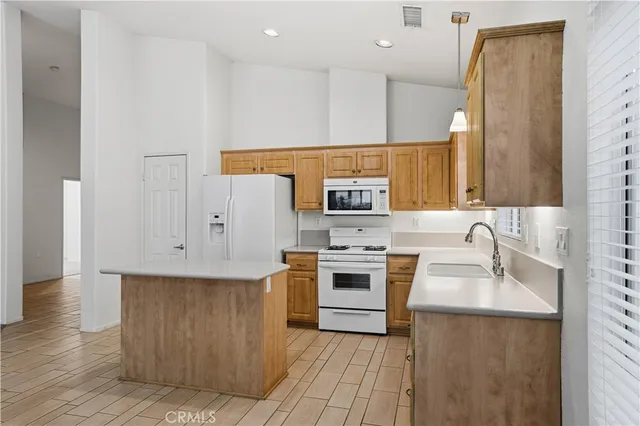 wooden floor in an empty room with a fireplace and a window