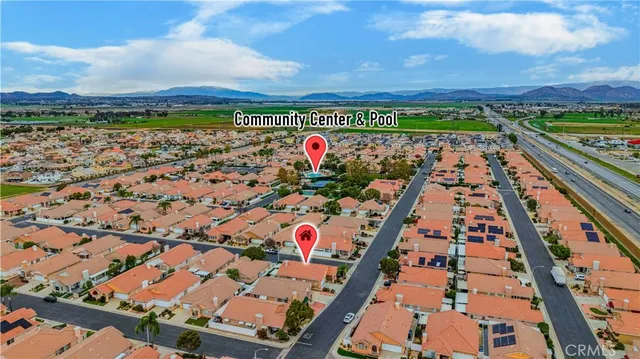 an aerial view of a city with lots of residential buildings ocean and mountain view in back