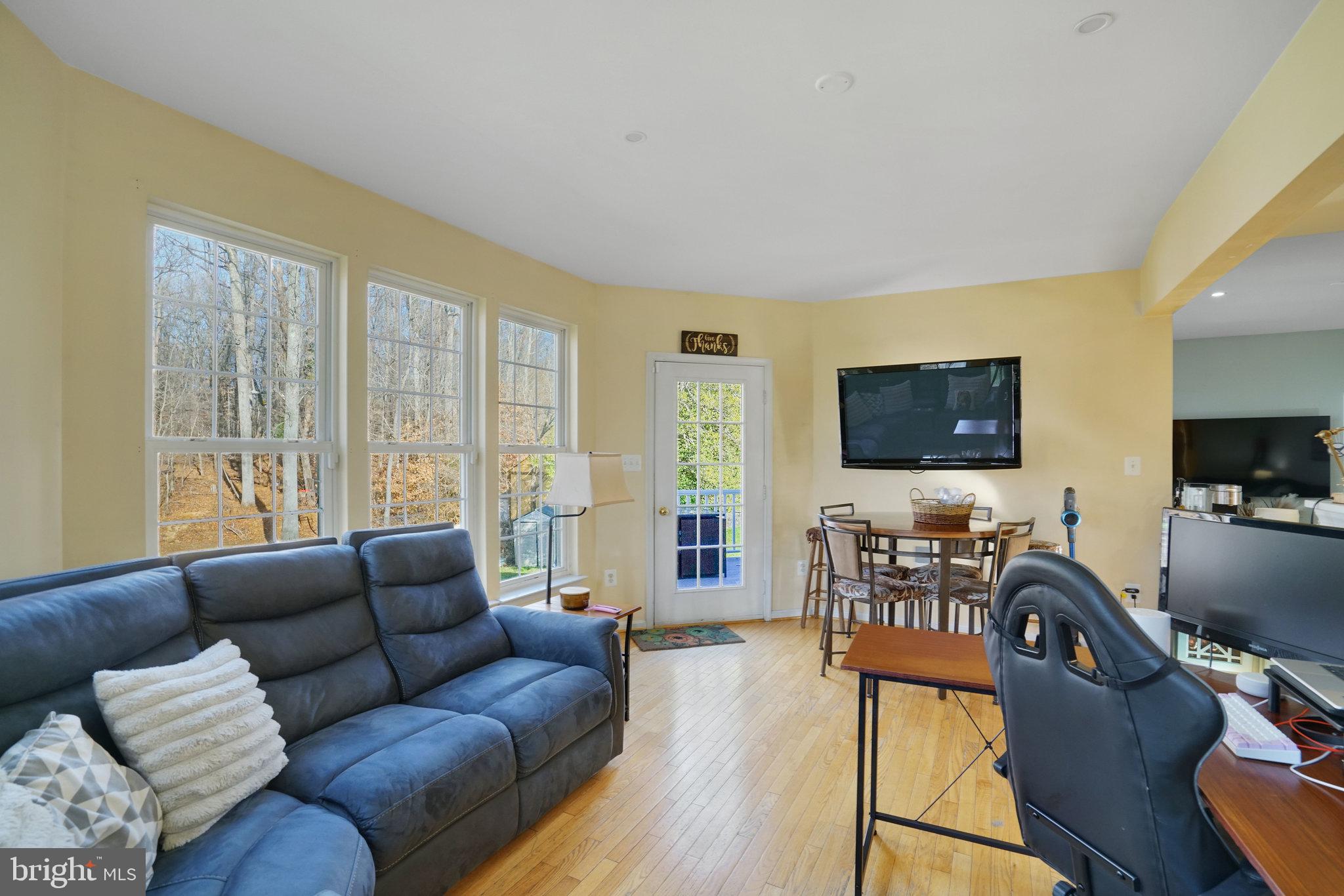 5026 Fallen Timber Way Indian Head, MD 20640 - Photo 16 of 62 a living room with furniture floor to ceiling window hardwood floor and a flat screen tv