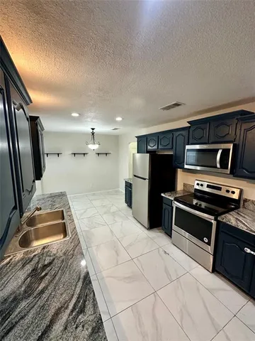 a kitchen with kitchen island a stove and a refrigerator
