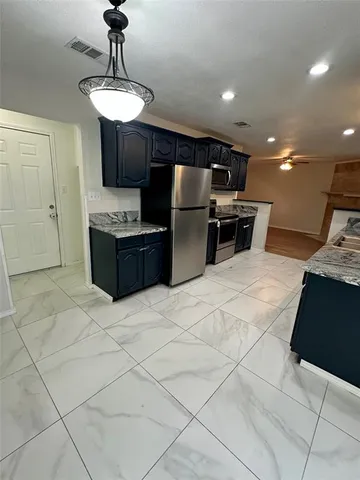 a kitchen with stainless steel appliances kitchen island granite countertop a sink and cabinets