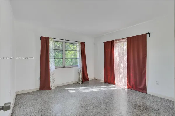 an empty room with windows and closet area