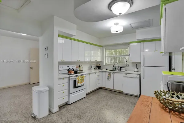 a kitchen with white cabinets and refrigerator