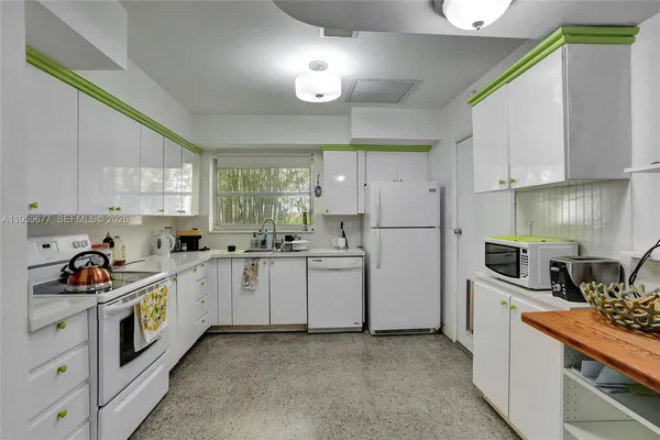 a kitchen with white cabinets and white appliances