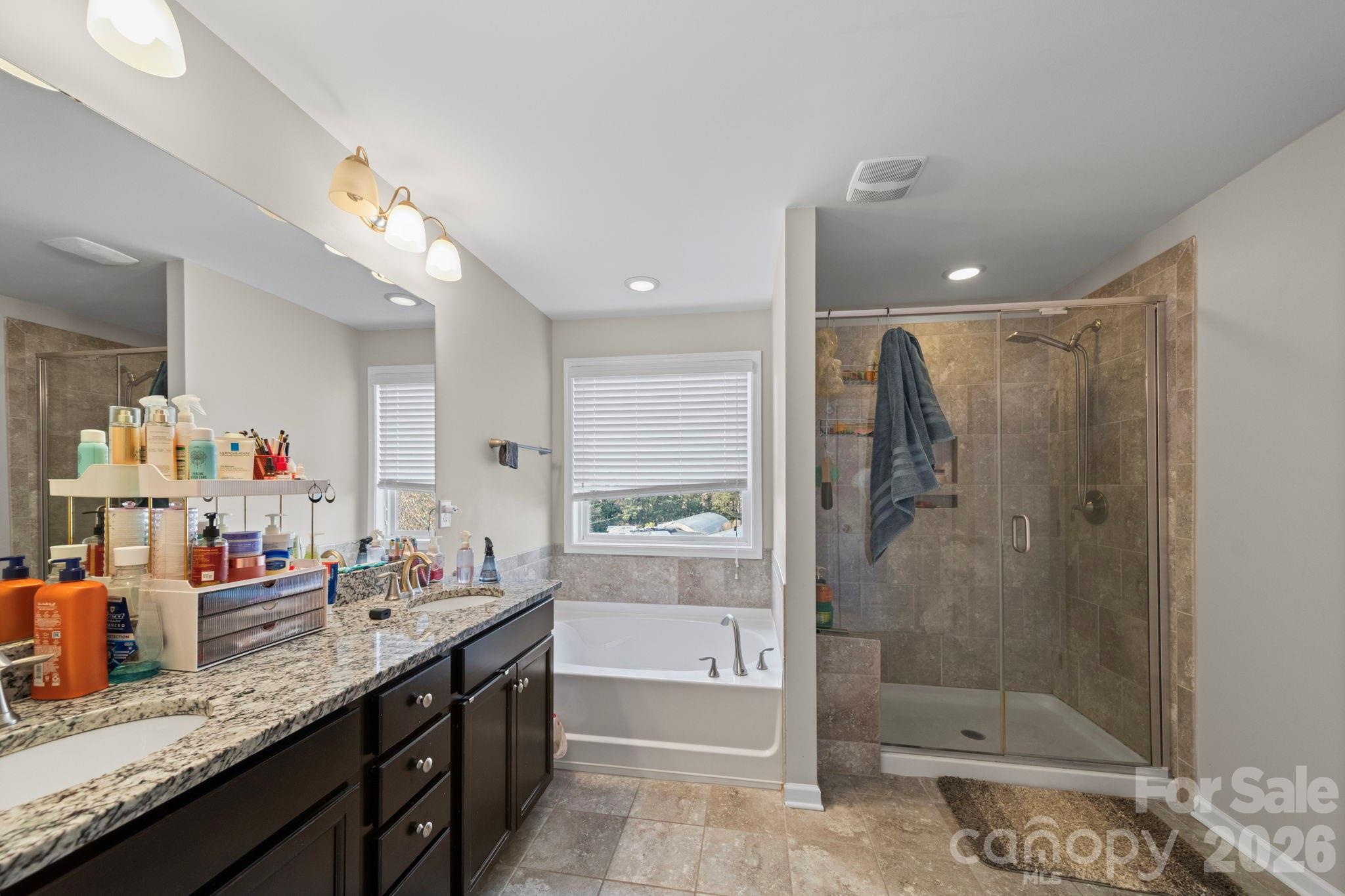 1425 Bramblewood Drive Fort Mill, SC 29708 - Photo 32 of 44 a bathroom with a granite countertop sink a large mirror and shower