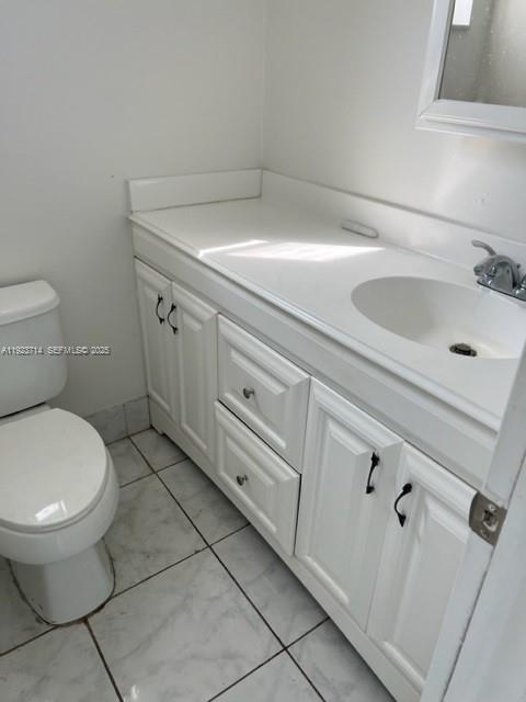 8001 Crespi Boulevard, Unit 2D Miami Beach, FL 33141 - Photo 16 of 20 a bathroom with a toilet sink and mirror