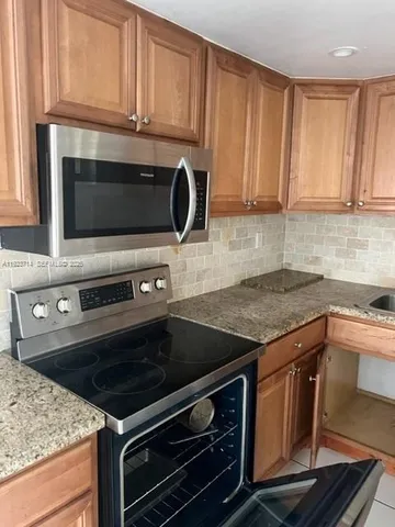 a kitchen with granite countertop a stove and a sink