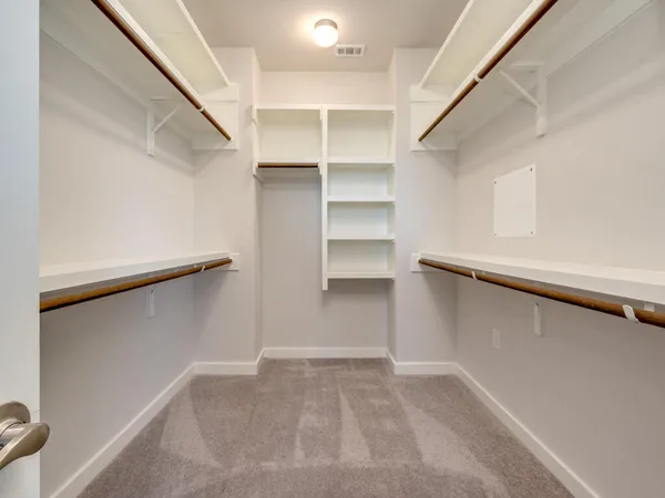 a view of walk in closet with empty racks