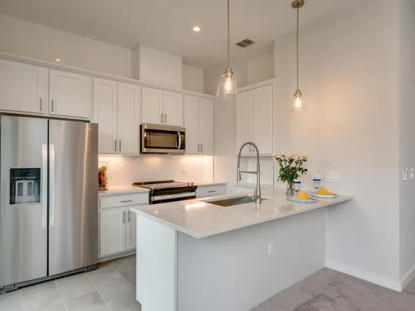 a kitchen with stainless steel appliances a refrigerator sink and microwave