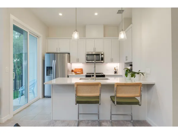 a kitchen with kitchen island white cabinets and stainless steel appliances