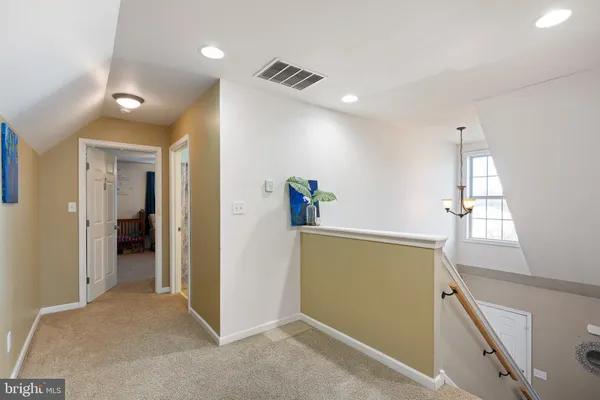 a view of hallway with furniture and a wooden floor